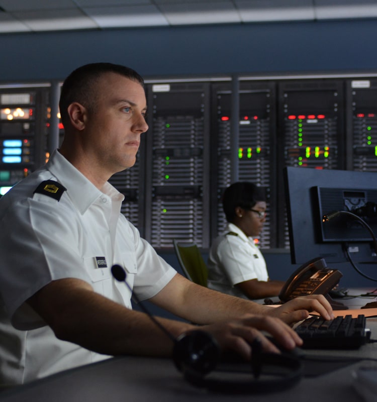 White male soldier in tech server room working on computer