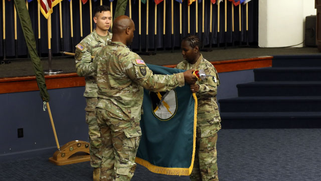 Three soldiers case 1st IO's colors at an inactivation ceremony